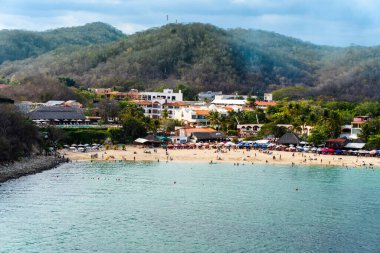 Huatulco, Oaxaca, Meksika La Crucecita 'nın güneyinde Santa Cruz Körfezi. Sahil, barlar, restoranlar ve oteller 1980 'lerde Meksika' nın turizm geliştirme ajansı FONATUR tarafından geliştirildi..