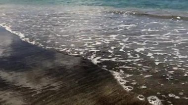 Waves on black sand beach from Nevis Peak Volcano. Pinney's Beach (Pinneys Beach) on western coast of the island of Nevis, in Saint Kitts and Nevis, Leeward Islands, West Indies in the Caribbean Sea.