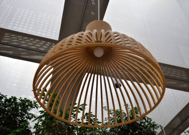 Gölge. Ahşap abajur doğal renklerde esnek ahşaptan ince tahtalardan yapılır. Tavan kirişinden askıya alınmış. Abajur şekli açık bir çiçeğe benziyor..