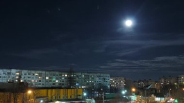 Zaman aşımı. Dolunay, eski komünist dönemin binalarının tepesinde yükseliyor.. 