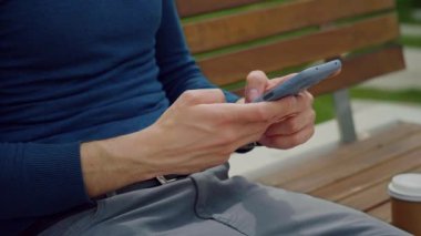 Cep telefonu kullanan bir adam. Açık hava parkına akıllı telefondan mesaj yazıyorum. Cep telefonu için bir uygulama indiriyor. Bir telefon tutuyorum. Teknoloji kullan.