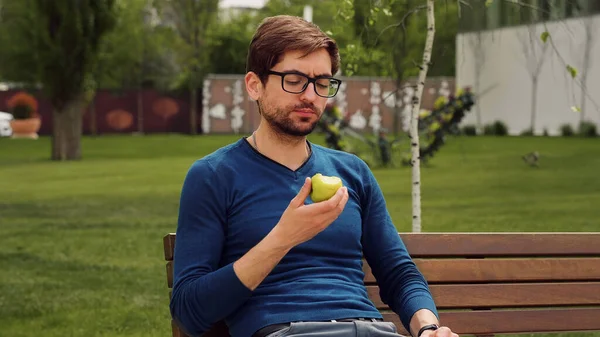 休憩を取る従業員 若い男は軽食としてリンゴを食べる 果物を楽しむ — ストック写真