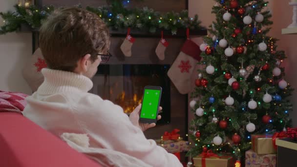 Handsome Man Possesso Smartphone Con Schermo Verde Sullo Sfondo Natale — Video Stock