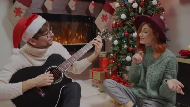 若い幸せな家族のカップルは一緒に笑って歌い 気楽な喜びの夫と妻はクリスマス休暇を楽しんで — ストック動画