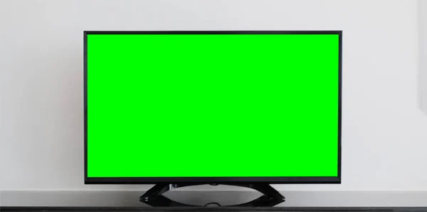 TV with Horizontal Green Screen on the black table with white background.