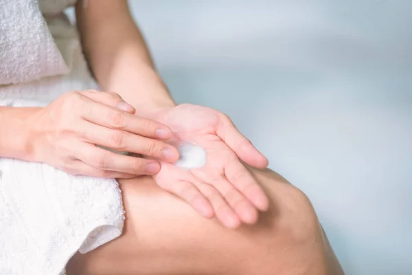 Asia woman applying moisturizing cream/lotion on hands, beauty concept.