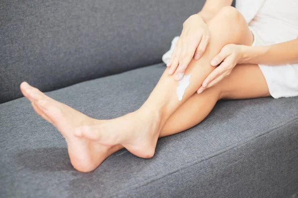 Woman applying natural cream, Woman moisturizing her leg with cosmetic cream with copy space.