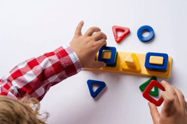 Çocuk ayırıcı yapıcıyı topluyor. Bulmaca çözücü, erken gelişim kavramı. Çocuk elleri bulmacayı masaya koydu. Çocuklar için sınıfları çal.