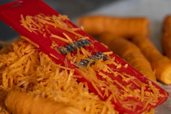 grating carrots on a grater for korean carrots , lifestyle, cooking, healthy eating.