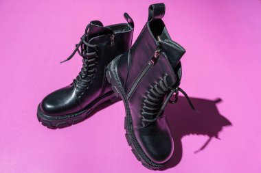 Leather Black Women's Rough Boots with Thick Soles, Laced High Fashion Boots, Rough black women's soldier boots on a pink background clipart