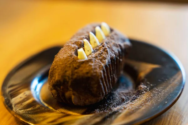 Potato cake on a saucer, Chocolate rum cakes, Dessert decorated with cream and cocoa, tea party, coffee break