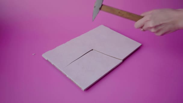 Молоток в руках девочек разбивает керамическую плитку на куски — стоковое видео