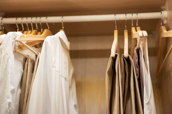 Roupas, camisetas, vestidos pendurar em um cabide no armário de casa — Fotografia de Stock