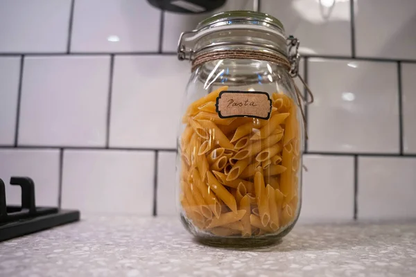 Macarrão em copos para armazenamento doméstico na cozinha — Fotografia de Stock