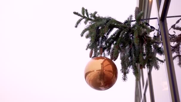 Świąteczna kula kołysząca się na wietrze na gałęziach jodły — Wideo stockowe