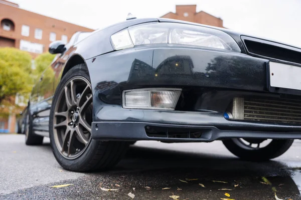 Clássico preto japonês poderoso carro sedan no outono paisagem urbana — Fotografia de Stock