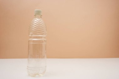 empty plastic bottle with screw cap on pink background