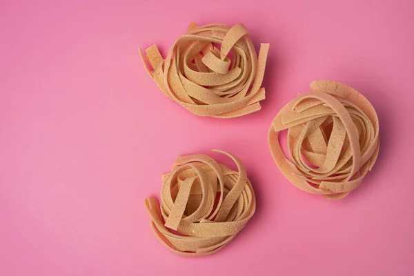 Três Ninhos Tagliatelle Raw Fundo Rosa Ninhos Macarrão Ninhos Pasta — Fotografia de Stock