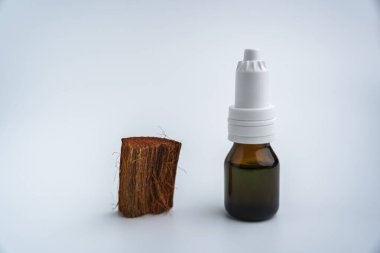 Beyaz arka planda bir şişe aromatik yağ. İçinde ilaç olan bir şişe.