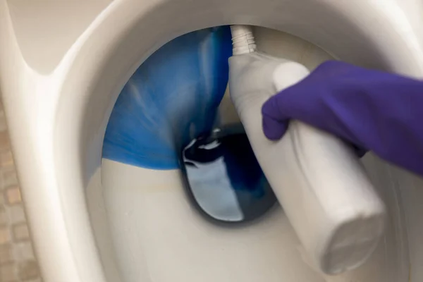 Lavar o vaso sanitário no banheiro com detergente e luvas de borracha — Fotografia de Stock