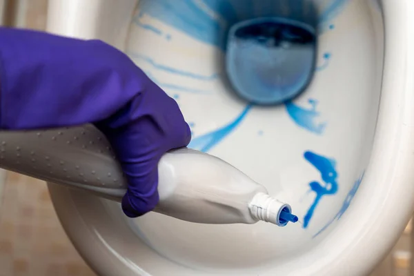 As mãos de limpeza lavar o vaso sanitário no banheiro com detergente e luvas de borracha — Fotografia de Stock