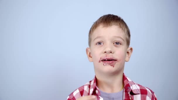 Αστείο Καυκάσιο αγόρι 5 ετών τρώει χαρούμενα μαρμελάδα από ένα βάζο με κουτάλι — Αρχείο Βίντεο