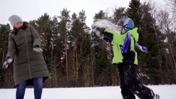 Glad söt vit mamma och son 5 år gammal ha kul att spela snöbollar — Stockvideo