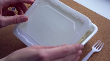 Eller, kaynar suyla dolu bir kutu Çin eriştesinin kapağını kapatır. Yavaş çekim
