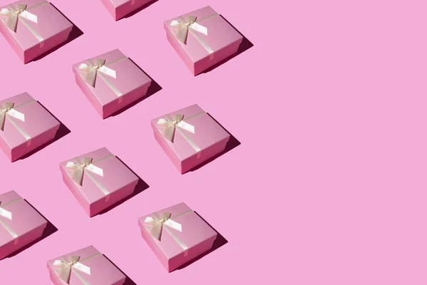 Pastel pembe arka planda pembe hediye kutusu deseni. Düz yerde, üst tarafta. Kış tatili fikri. Minimum Noel ve Yeni Yıl kutlaması konsepti. Kopyalama alanı ile. 