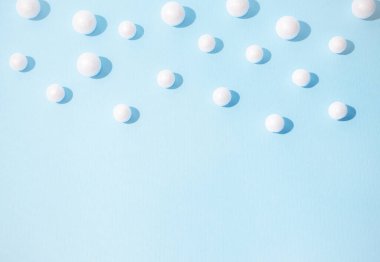 Pastel mavi arka planda kartopları. Yeni yıl ve Noel fikri. Kış tatili konsepti asgari düzeyde. Boşluğu kopyala.