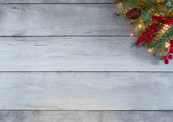 Yaratıcı kış tatili planı. Noel ağacı ışıklarından, çam ağacından, kırmızı böğürtlenlerden ve beyaz tahta konilerden yapılmış. Minimum yeni yıl ve Noel konsepti geçmişi. Kopyalama alanı ile.