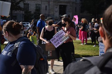 Washington, DC, ABD - 2 Ekim 2021: İki kadın, Özgürlük Meydanı 'nda düzenlenen Kadın Yürüyüşünde Geleceğimizle Mücadelemiz Bedenlerimiz 