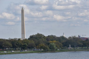 Washington, DC, ABD - 25 Ekim 2021: Washington Anıtı ve ABD Kongre Binası Tepesi Tepesi 'nin tepesi Potomac Nehri' nin karşısındaki ağaçlardan görüldüğü gibi