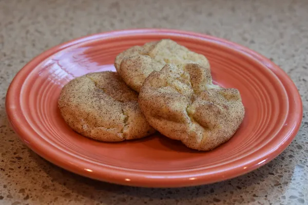 Turuncu bir tabakta ev yapımı üç kurabiye yakın plan.