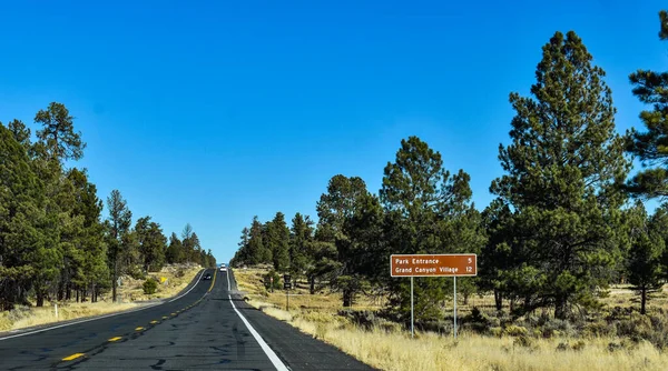 Tusayan, Arizona, ABD - 11 Kasım 2021: Grand Canyon Ulusal Parkı 'na yaklaşırken, trafik levhası sürücüleri park girişine olan mesafeyi bildirdi