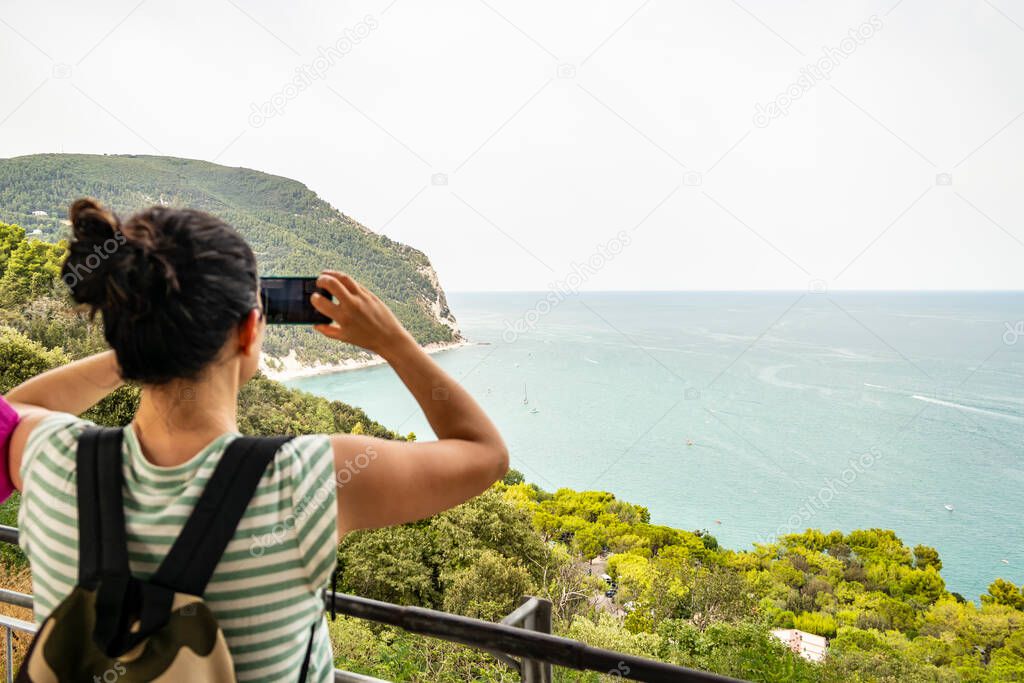 Girl photographing the sea from Sirolo, Marche - Italy