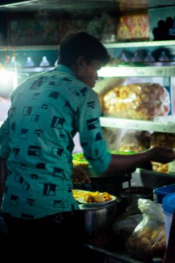 A picture of a street vendor selling bhel puri in Indian streets (Bhelpuri is a savoury snack originating from India, and is also a type of chaat)