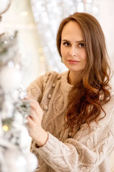 若いです女性でA Beigeニット暖かいセーターとブルージーンズ上のクリスマス装飾の背景 — ストック写真