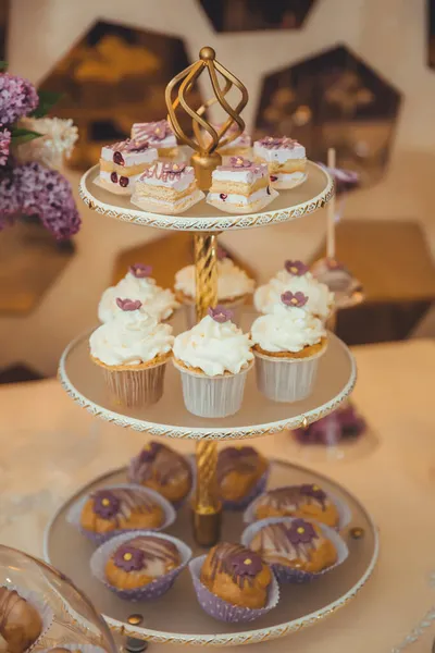 황금색 쟁반에 크림으로 장식된 컵케이크와 케이크 — 스톡 사진