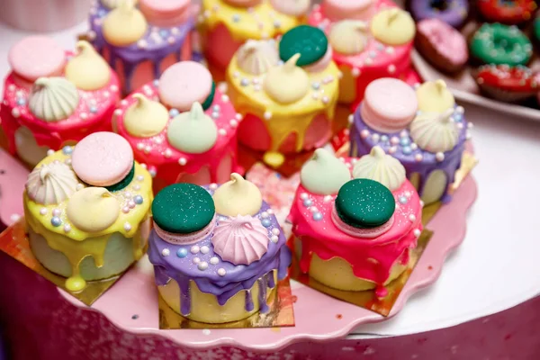 色彩艳丽的甜甜圈和蛋糕 用糕点 蛋白蛋白和金银花装饰 放在桌上 — 图库照片