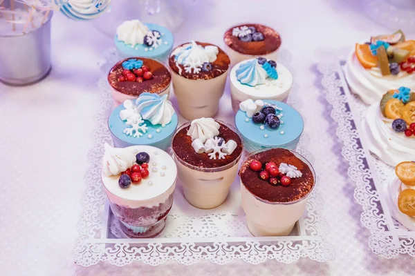 提拉米苏洒上可可豆 用蓝莓 焦糖化雪片 麦片和棉花糖装饰 放在托盘上的透明塑料杯中 — 图库照片