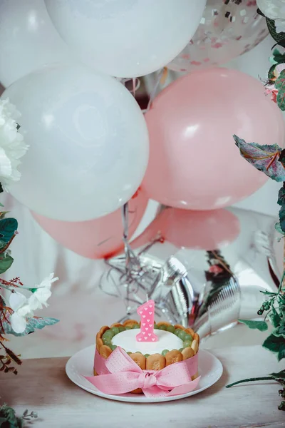带有粉色蝴蝶结的提拉米苏蛋糕和装饰有葡萄和气球的头号蜡烛 — 图库照片