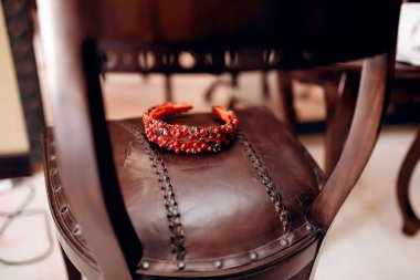 Kırmızı ve şeffaf boncuklar ve kırmızı ve yeşil boncuklar kırmızı deri koltukta yatar.