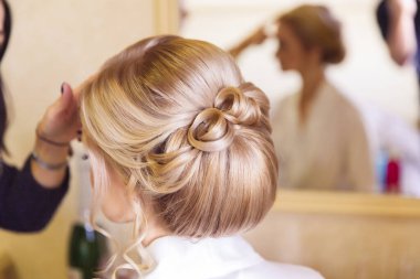 Kuaför, kuaförde sarışın gelinin saç modelini tamamlıyor.