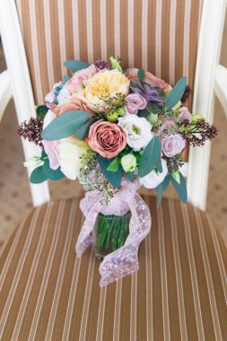 Beyaz sandalyede düğün buketi, fotoğraf stüdyosu, düğün nitelikleri. Pembe güller, okaliptüsler.