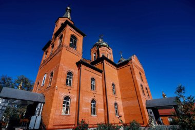 Bulutlu gökyüzünün arka planında altın kubbeleri olan Ortodoks Rus tapınağı