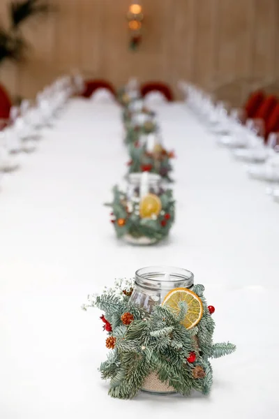 餐桌上摆满盘子 餐具和餐巾 烛台装饰着云杉枝条 一片干橙 织物和人造浆果 — 图库照片