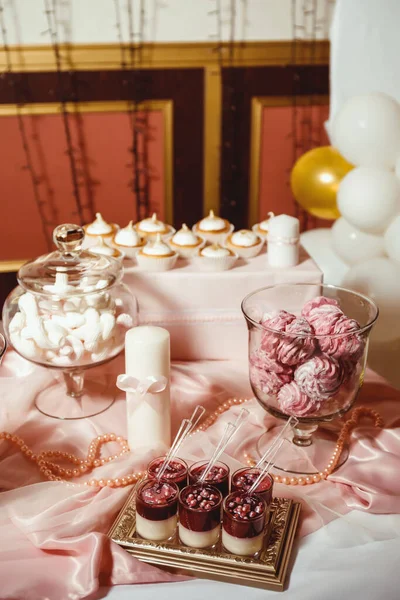 베이지 배경에 쟁반에 분홍색 크림이 황금색 과자로 장식된 컵케이크 — 스톡 사진