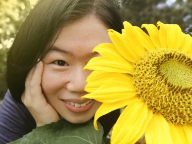 Ayçiçekli güzel, neşeli kadın doğanın tadını çıkarıyor. . 