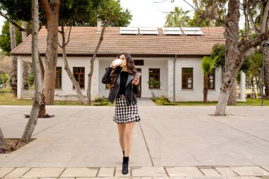 Kahve iç, genç kadın kahve içerken yürümeye devam et, güzel kadın yoğun çalışma programına ayak uydurmaya çalışıyor.